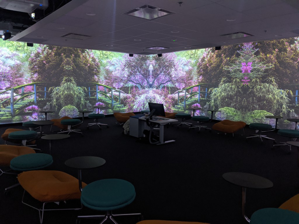 An image of a purple garden projected onto walls of the Immersion Studio